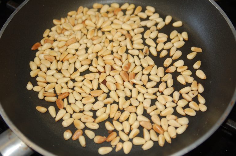 Toast pine nuts over medium heat.  Toss frequently and don't leave them alone.  They burn very easily.  
