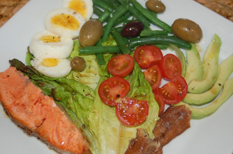 Salmon nicoise salad with cherry tomatoes, string beans, sardines, olives and soft boiled eggs.