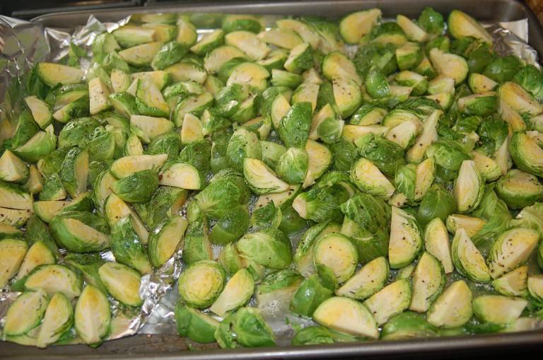 Cut the Brussels sprouts into quarters and toss in olive oil.