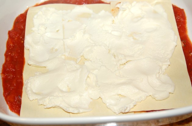 Gently spread a thin layer of ricotta cheese over lasagna noodles.